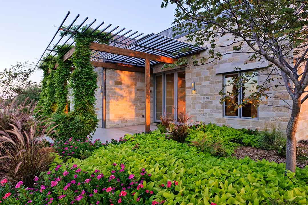 casa muy eficiente energéticamente con muros de aislamiento jardín, arenas, piedras y paneles solares