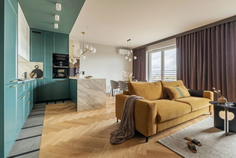 reformas integrales en L'Hospitalet - cocina muy luminosa y detalle de isla y mesa del comedor y sofá en primer plano